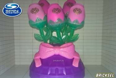 Букет из пяти цветов с бутонами на фиолетовой подставке с розовым с блестками бантом